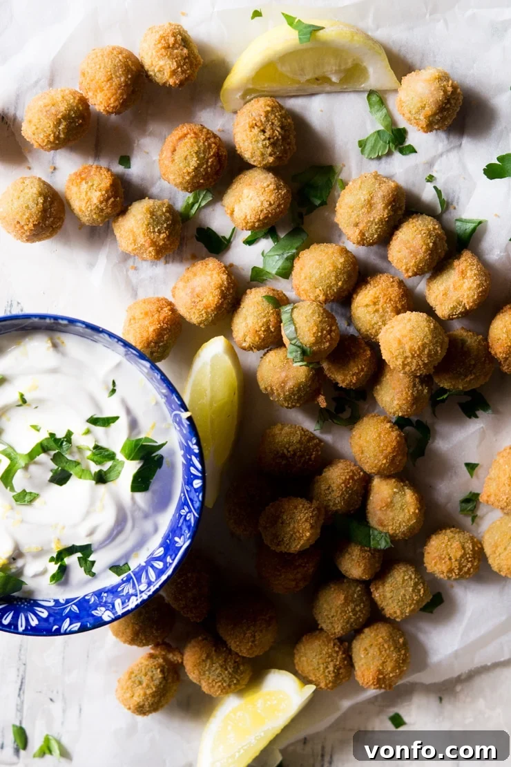 An overhead shot of fried stuffed olives and a sour cream dip