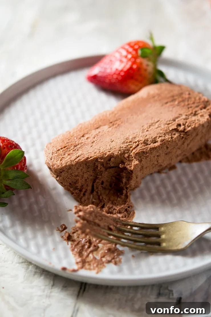 A close up of a slice of chocolate semifreddo on a plate with a bite on a fork, showcasing an easy semifreddo recipe