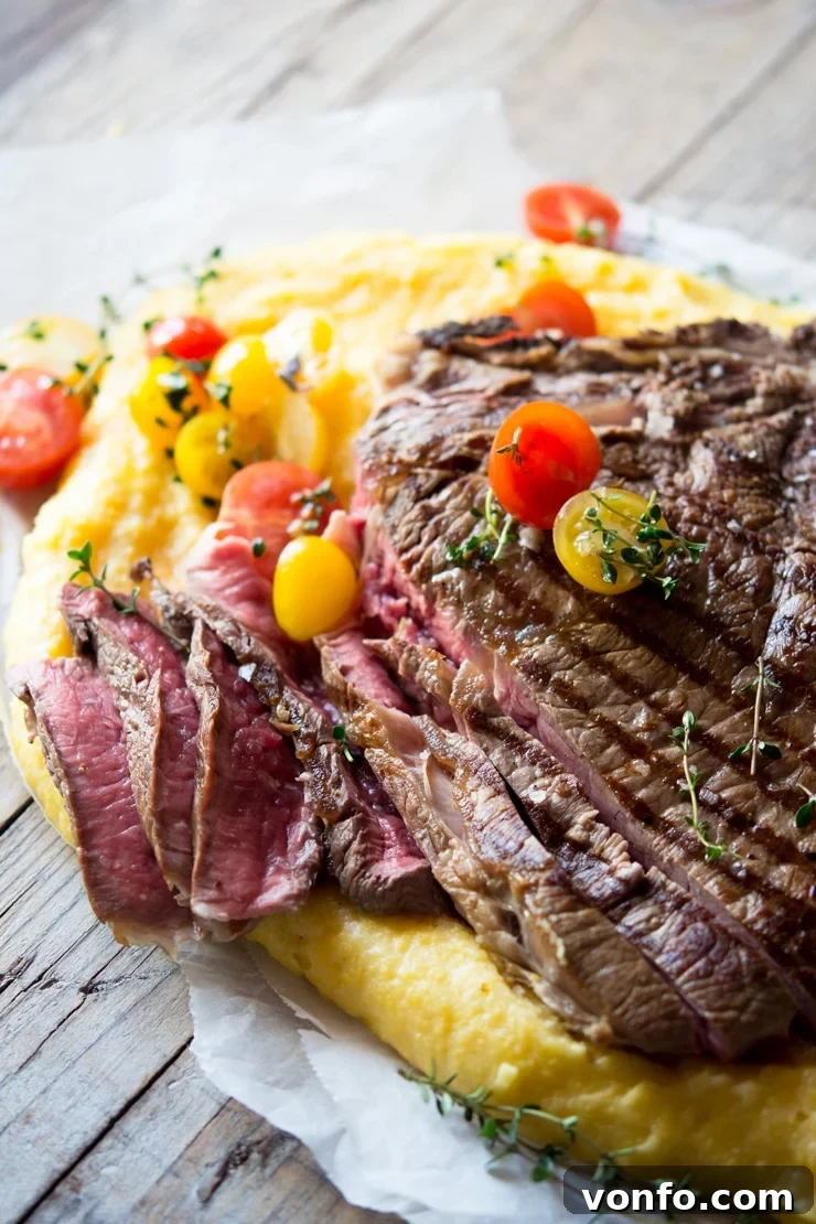 Sliced Rare Florentine Steak A side view of a rare Florentine steak, expertly cut into thick, juicy slices and adorned with vibrant cherry tomatoes, ready to be served.