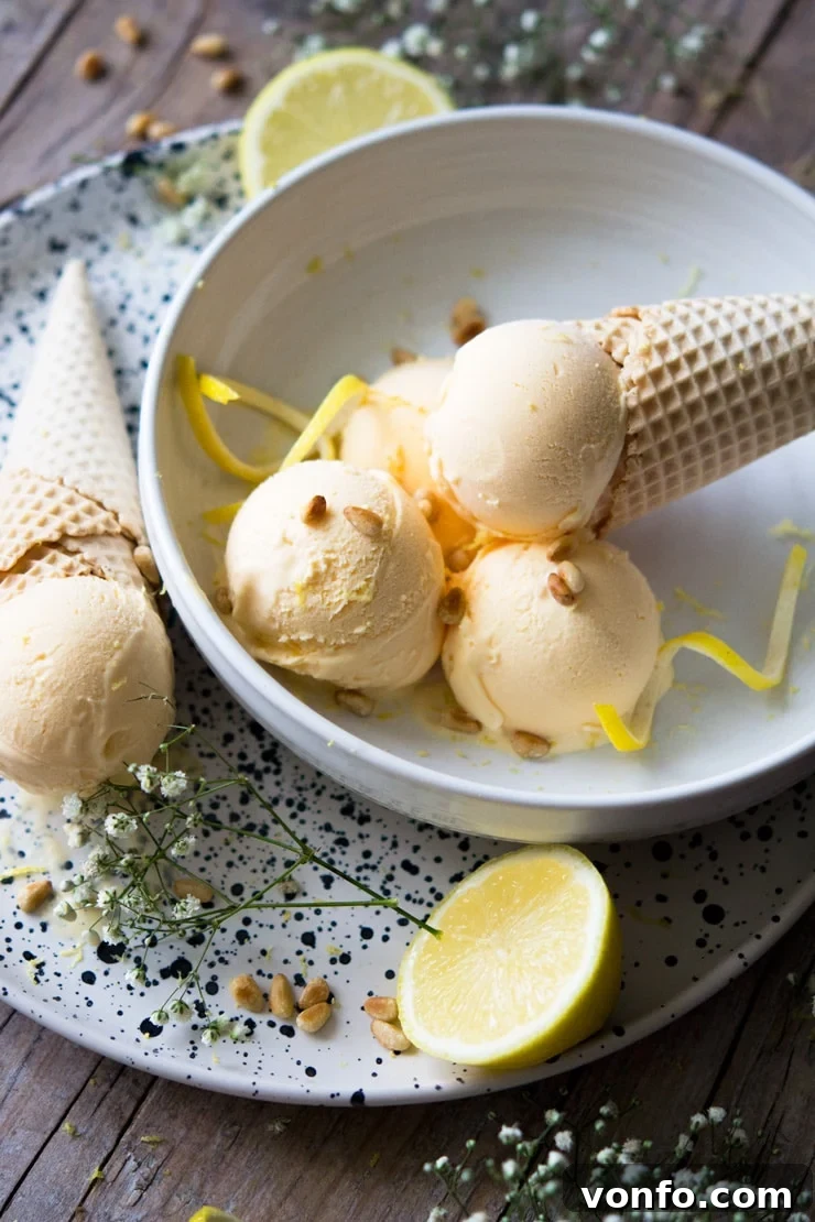 Amalfi Lemon Limoncello Gelato 3 A tantalizing side shot of scoops of Lemon Ice Cream nestled in a bowl, with a crisp ice cream cone poised beside it, symbolizing pure summer bliss.