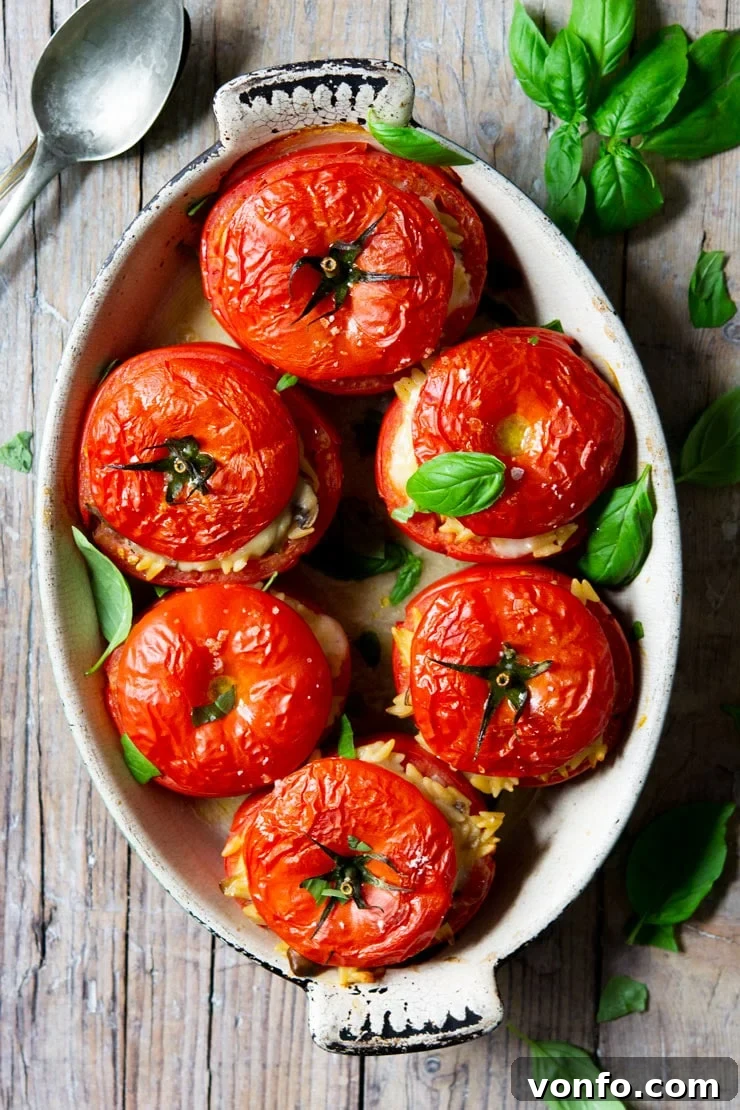 Savory Baked Orzo Tomatoes 2 Six baked stuffed tomatoes in an oval baking dish, glistening and golden