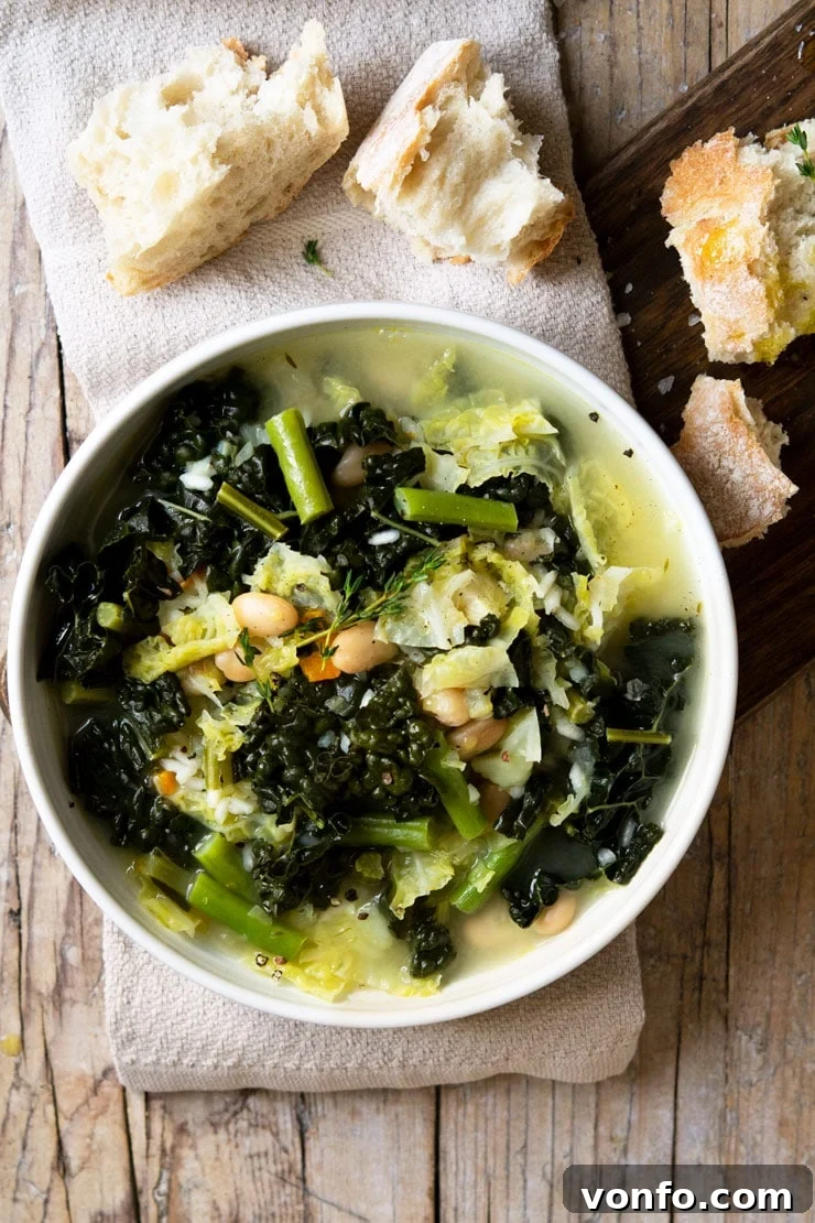 Tuscan Minestrone Soup: A hearty and comforting bowl of soup made with green vegetables and rice. This minestrone is so easy, delicious and perfect for a rainy day. | Italian Minestrone Soup | Authentic Italian Recipes | Italian Soup An overhead shot of Tuscan minestrone soup on a wooden surface