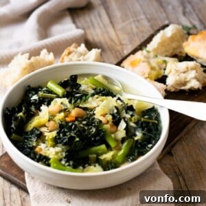 Hearty Tuscan Garden Minestrone 2 A bowl of Tuscan minestrone soup on a wooden surface with bread