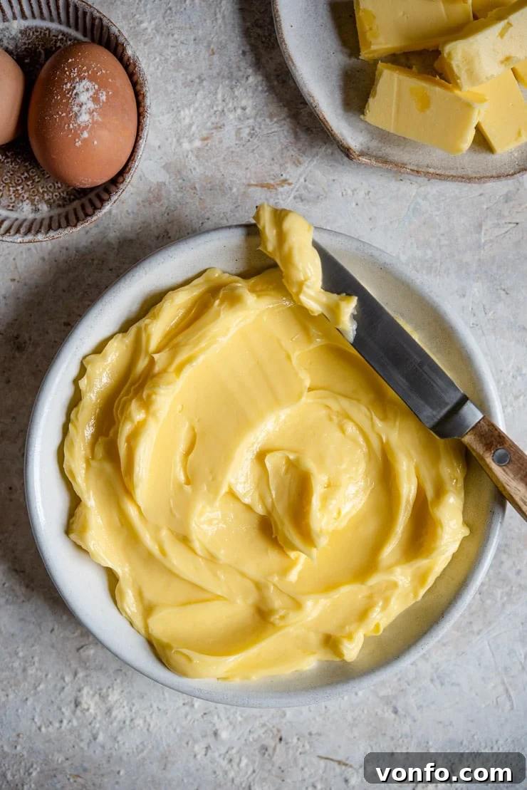 An overhead shot of perfectly softened butter in a rustic white bowl, ready for baking.