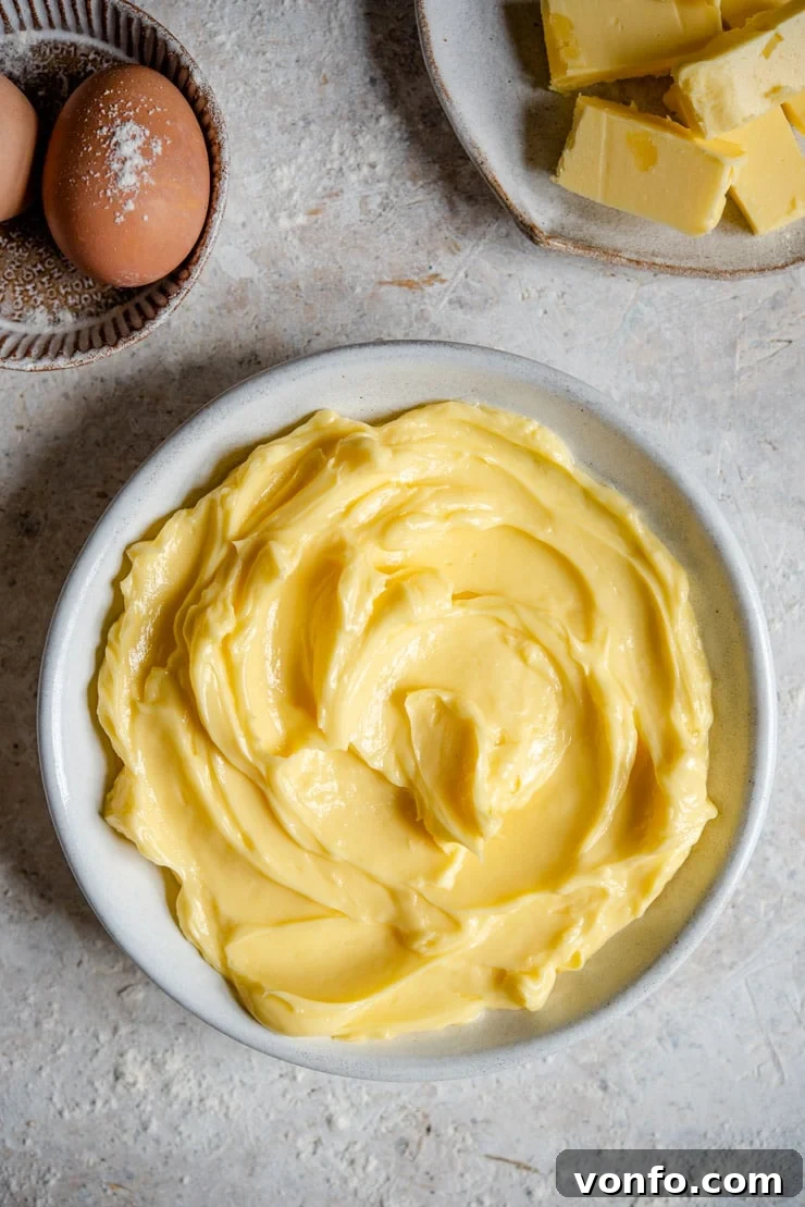 An overhead shot of softened butter in a bowl, ready to be used in a delicious baking recipe.