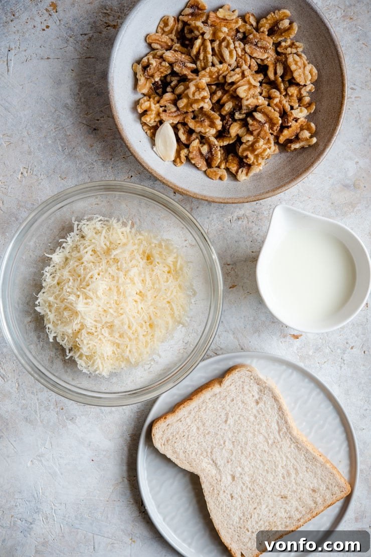 Key Ingredients for Homemade Salsa di Noci An overhead shot showcasing fresh walnuts, white bread, garlic, Parmesan cheese, milk, and olive oil, all laid out for making walnut sauce