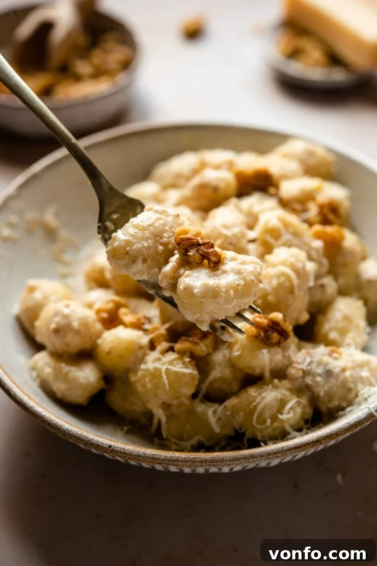 Creamy Gnocchi with Salsa di Noci on a Fork A close-up of a fork lifting tender gnocchi coated in creamy walnut sauce, ready to eat