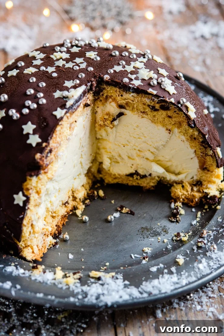 A close-up view of a beautifully sliced Panettone Bombe, revealing its creamy semifreddo and panettone layers.