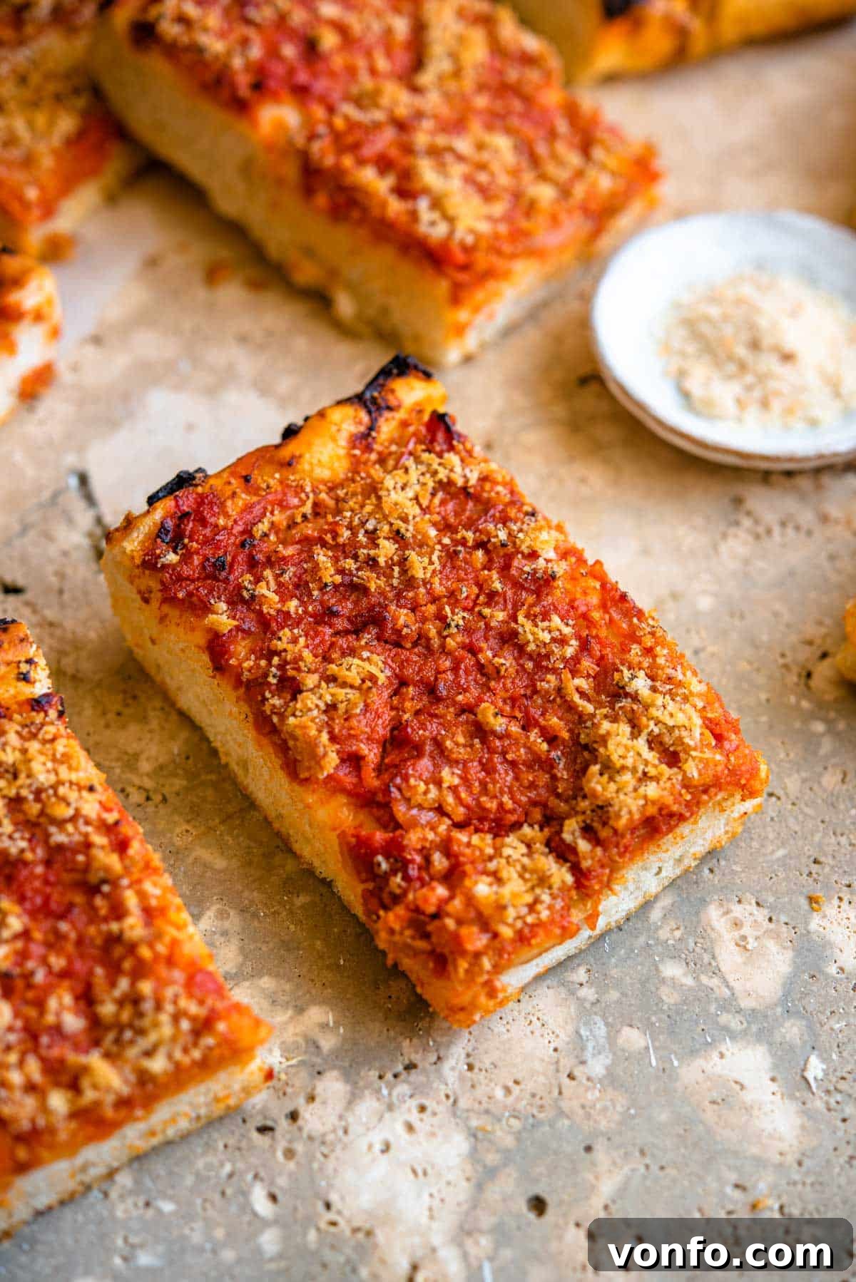Sicilian Sfincione Pizza 9 A close-up of a perfectly baked slice of Sicilian pizza (Sfincione) adorned with its crispy breadcrumb topping, ready to be enjoyed