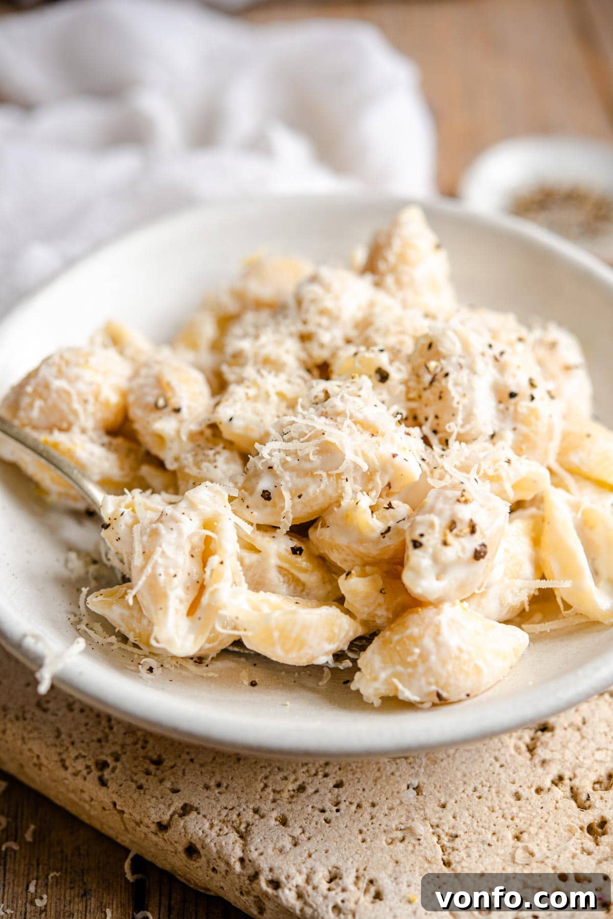 Two Irresistible Ricotta Pasta Sauces 6 A side shot of pasta shells with a ricotta sauce in a ceramic bowl, garnished with parsley