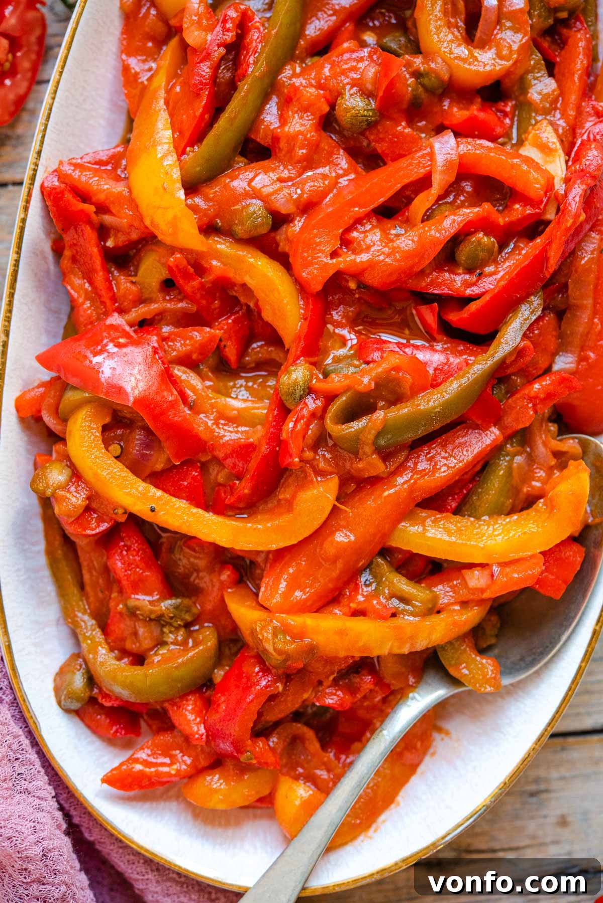Peperonata: Sweet Bell Peppers in Rich Tomato Sauce 6 A close up of peppers in tomato sauce on a serving plate, garnished and ready.