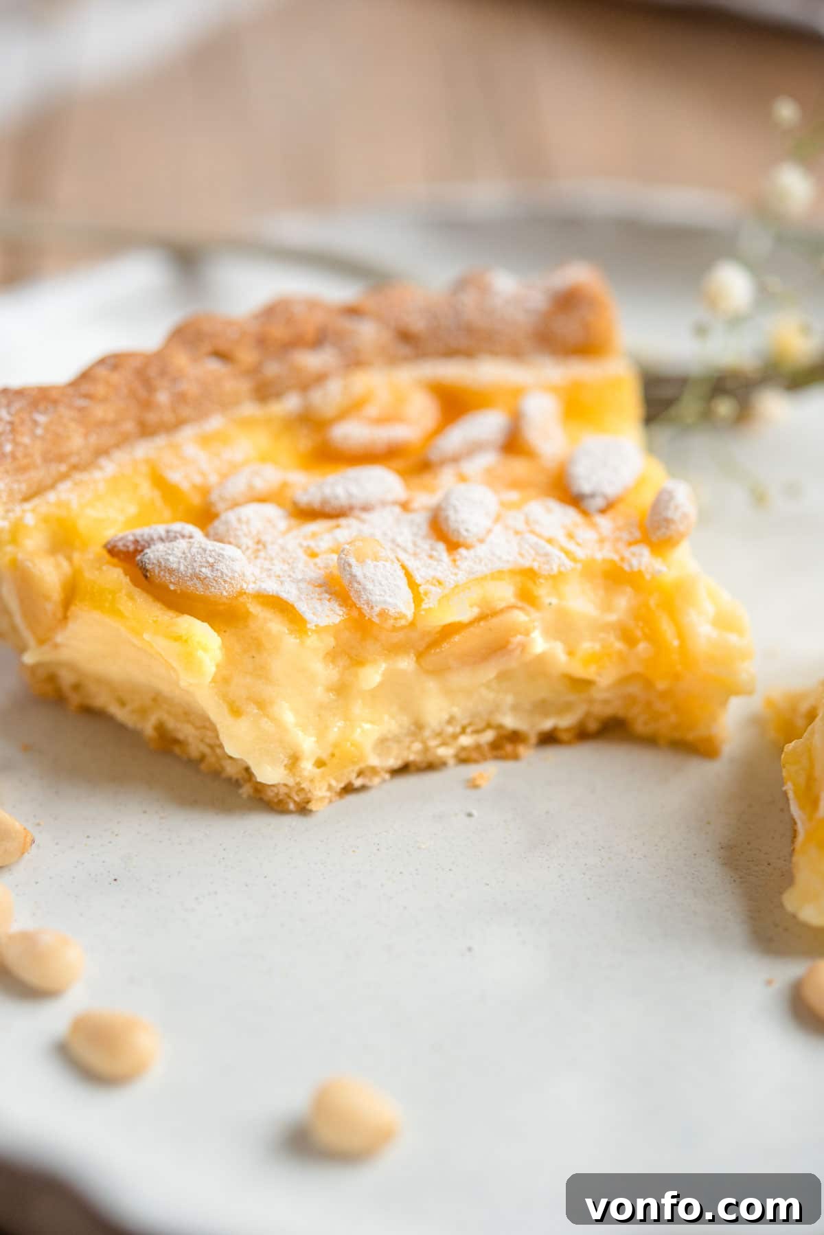 Torta della Nonna Italian Golden Custard Tart 14 A close up of a slice of torta della nonna with a bite out