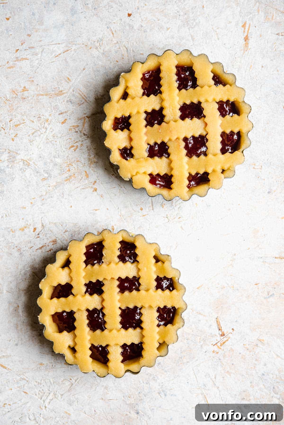 Traditional Italian Sweet Shortcrust Pasta Frolla 8 An overhead shot of two shortcrust pastry tarts, one with a lattice topping and one plain, before being cooked.