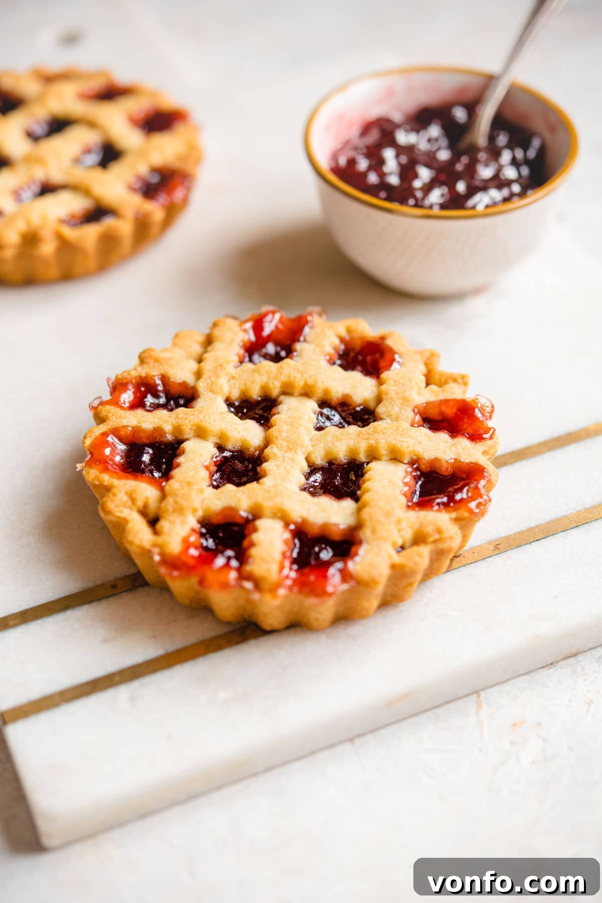 Traditional Italian Sweet Shortcrust Pasta Frolla 9 A mini Italian jam tart on a marble cutting board, showcasing the beautiful golden crust.