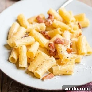 A square photo of a finished plate of Pasta alla Gricia, featuring rigatoni with guanciale and Pecorino Romano