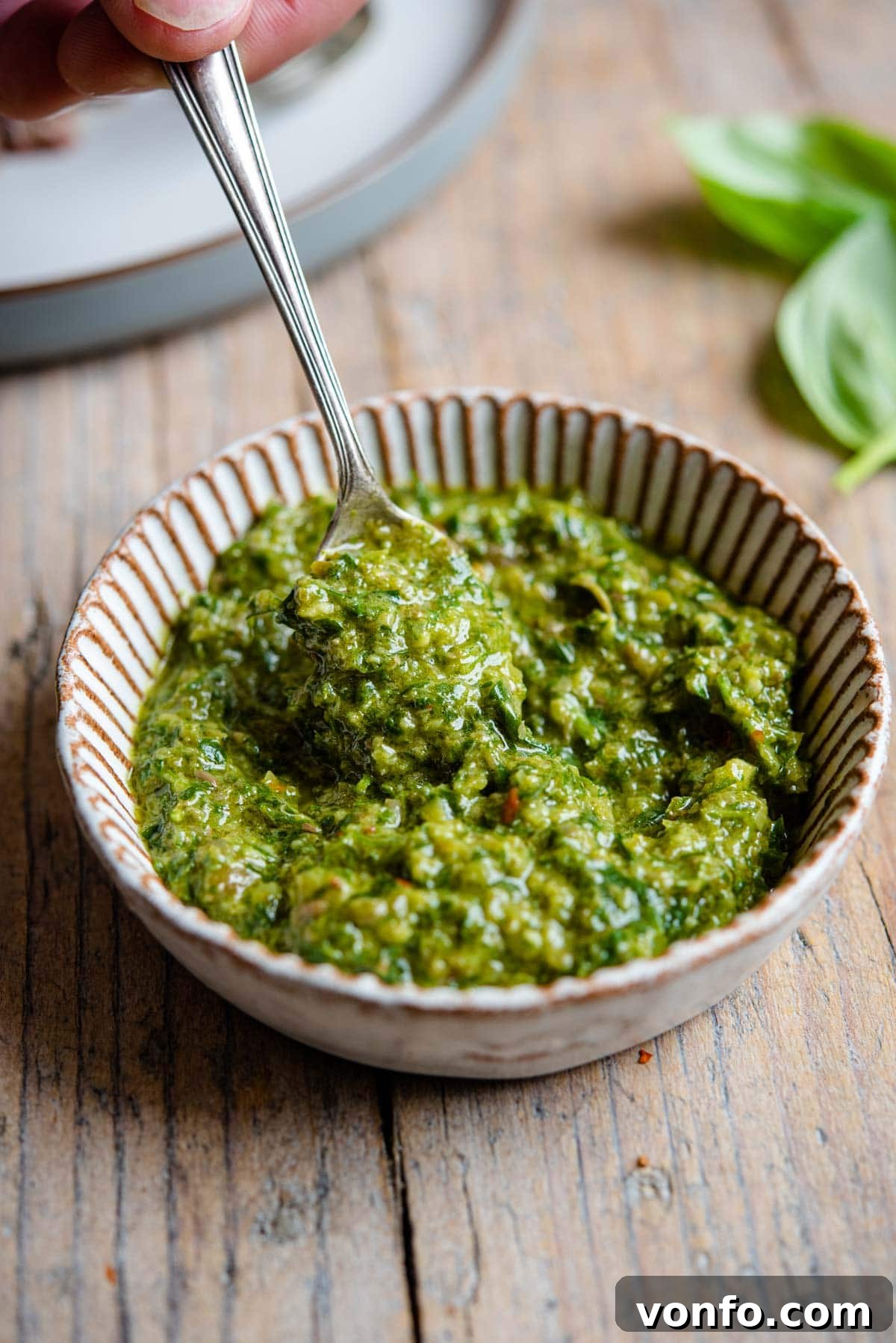 Vibrant Italian Salsa Verde 5 A close up of vibrant green Italian salsa verde in a small white ramekin, glistening with olive oil and ready to be served, highlighting its rich color and texture.