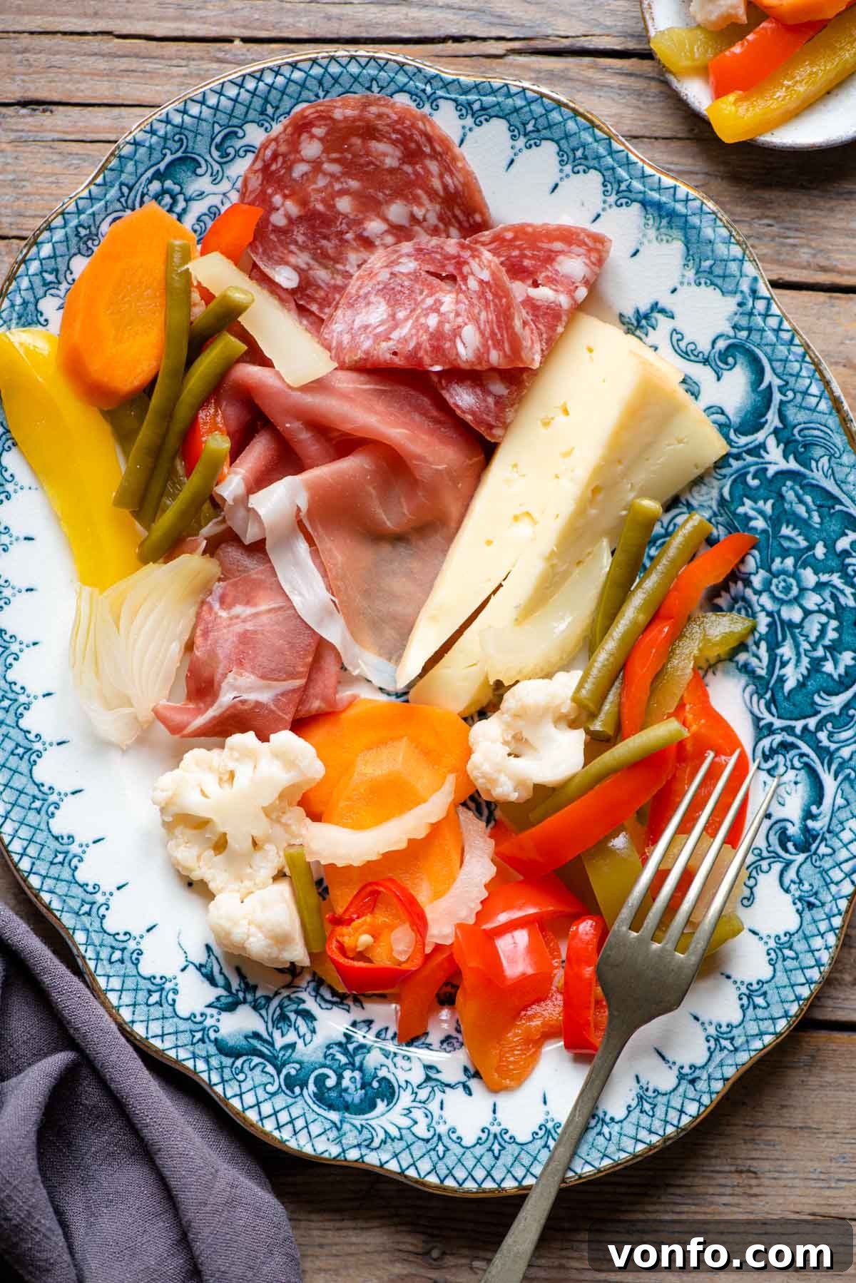 Italy's Tangy Vegetable Medley 5 Italian pickled vegetables on a platter with cured meats and cheese, ready to be served as antipasto