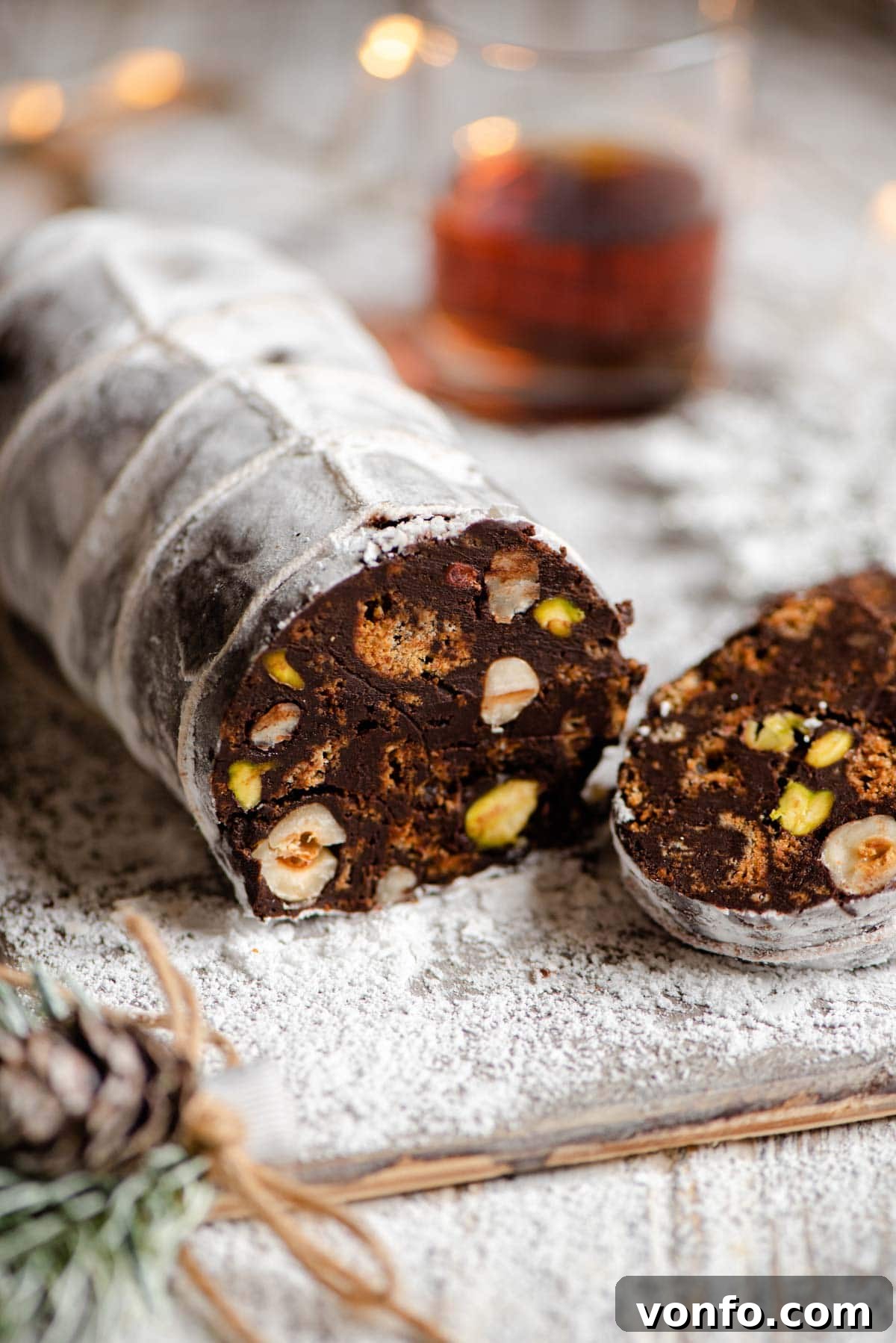A detailed close-up shot of a freshly cut chocolate salami slice, highlighting the rich chocolate, visible nuts, and cookie pieces within.