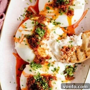 A close up of burrata with Nduja and gremolata, served on a plate.