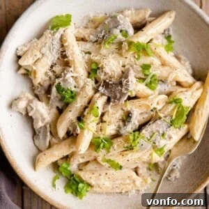 A close up of pasta alla boscaiola in a bowl, garnished with parsley.