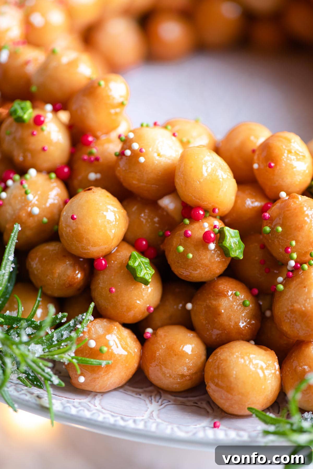 Struffoli Italy's Golden Honey Treats 8 A close-up shot of perfectly golden-brown Struffoli Italian honey balls, glistening with honey and adorned with colorful sprinkles, arranged in a festive mound.