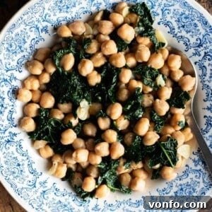 Finished garlicky chickpeas and cavolo nero in a blue and white bowl.