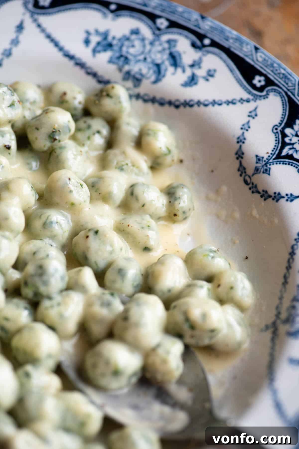 Pillowy Spinach Chicche in Velvety Parmigiano Butter 5 A close up of mini spinach and potato gnocchi with a creamy butter and parmigiano sauce.