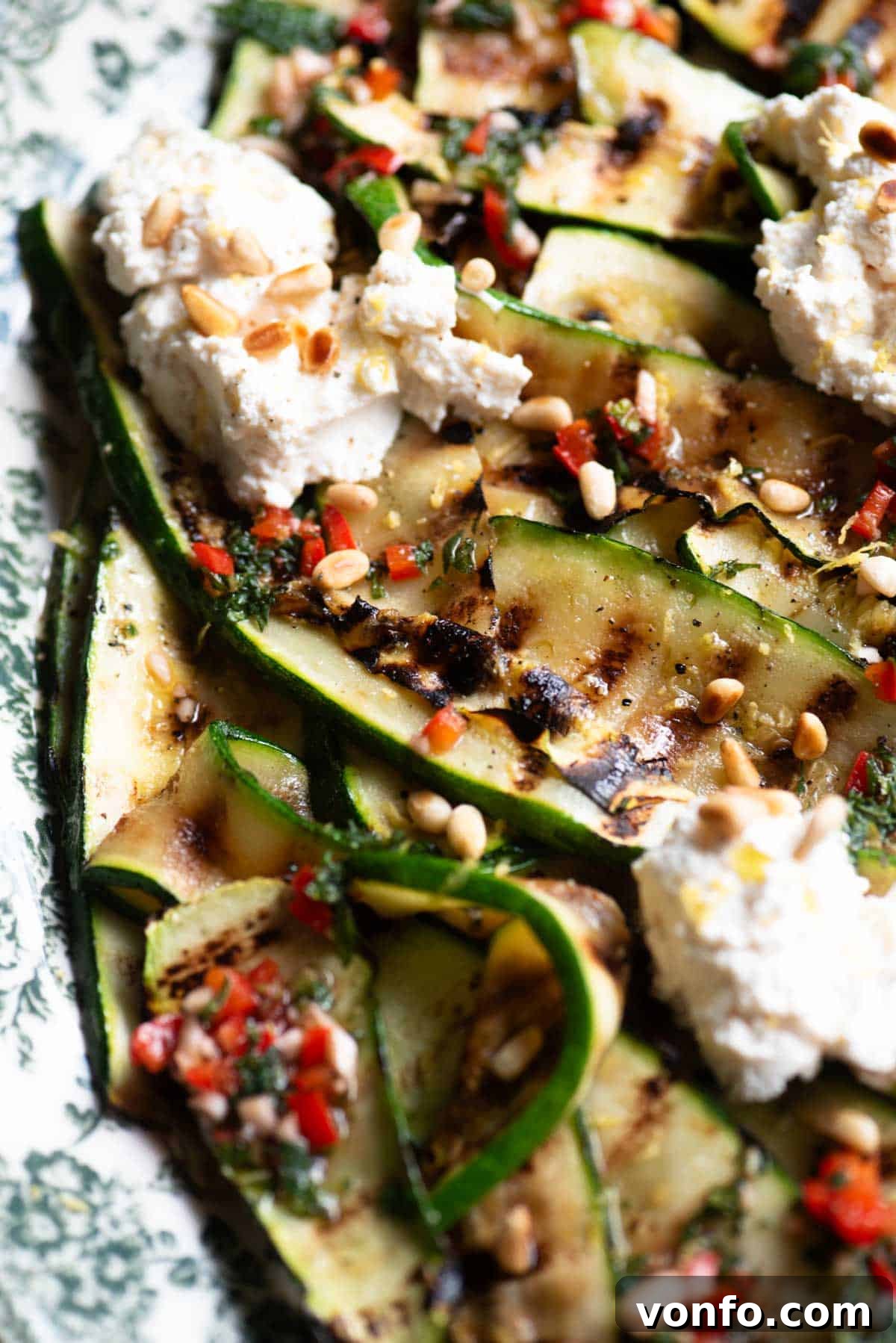 Grilled Zucchini with Creamy Ricotta and Toasted Pine Nuts 4 A close up side shot of grilled zucchini on a platter with mint, chilli, garlic and ricotta.