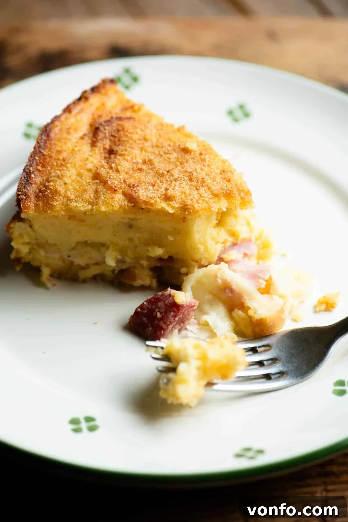 Ready-to-Eat Gattò di Patate A close up of a slice of Neapolitan potato cake (gatto di patate) served on a rustic plate with a fork, ready to be enjoyed.