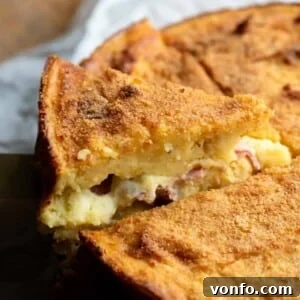 Neapolitan Cheesy Potato Bake 2 A close up of a slice of potato cake stuffed with cheese and ham, fresh from the oven.