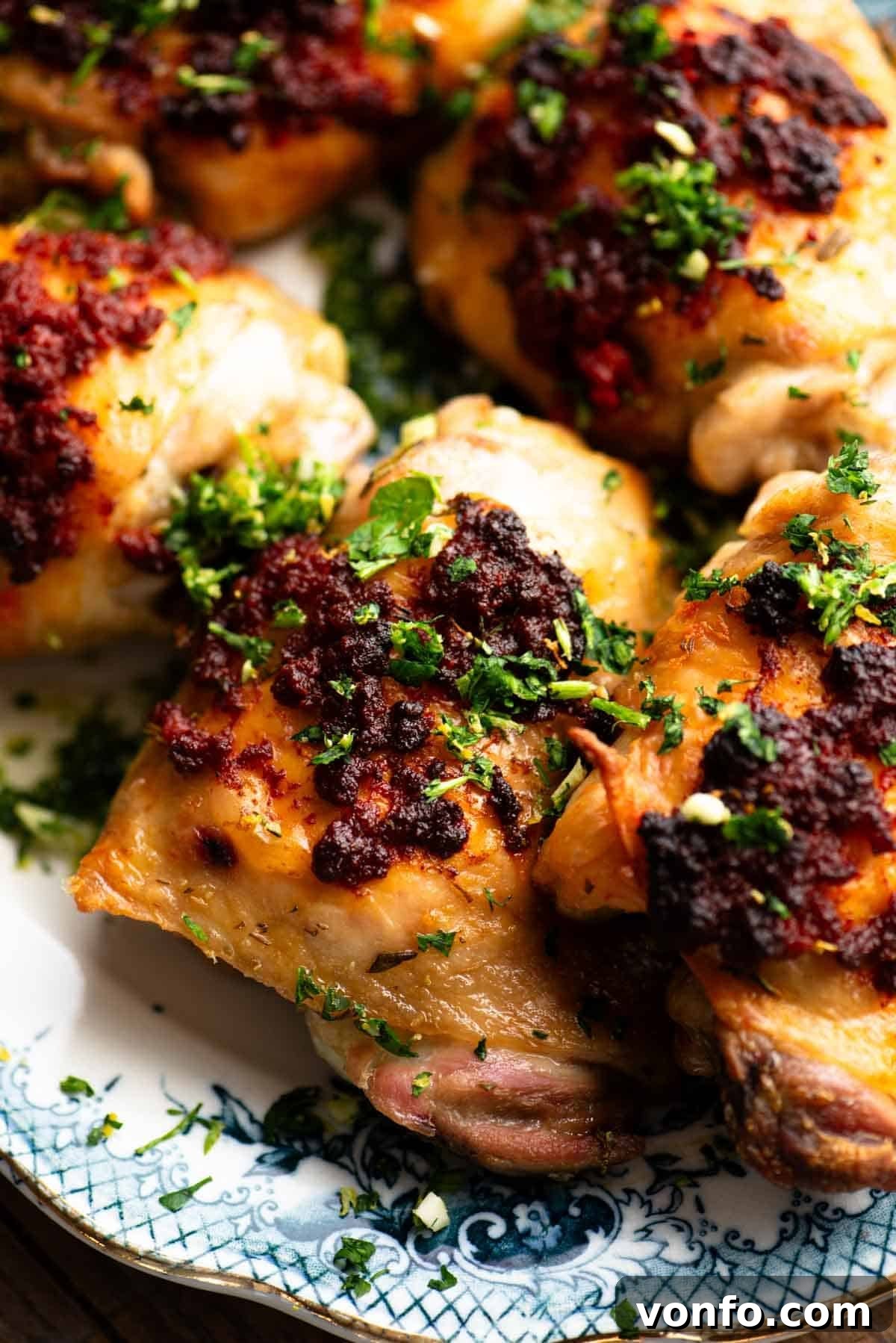 Nduja-Baked Chicken with Roasted Tomatoes and Herbs 4 A close up of Nduja baked chicken thighs topped with gremolata.