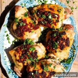 Nduja-Baked Chicken with Roasted Tomatoes and Herbs 5 Nduja baked chicken on a blue and white serving plate topped with gremolata.