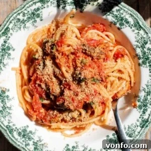 A close up of tomato sardine pasta topped with breadcrumbs.