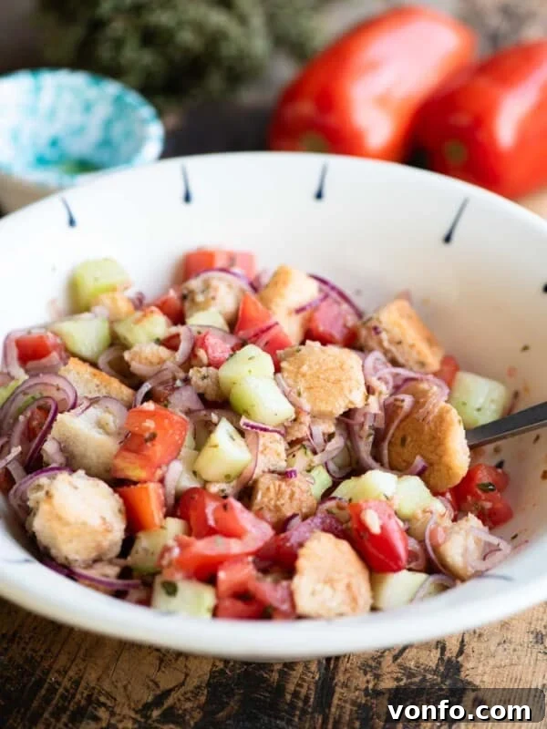 Cialledda salad in a white bowl sitting on a wooden surface.
