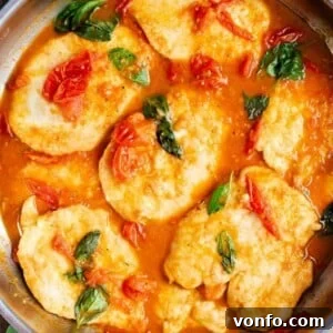 Cherry Tomato Basil Chicken Skillet with Garlic and Parmesan 5 A close up of chicken cutlets in a cherry tomato and basil sauce.