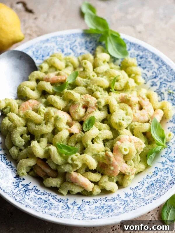 Sun-Dried Tomato Pasta Fredda: Chilled Mediterranean Pasta Salad 5 Zucchini shrimp pasta salad in a blue and white bowl topped with basil leaves.