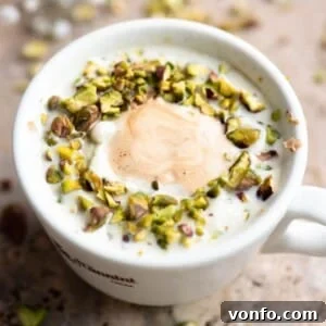 Pistachio Affogato Recipe: Creamy Pistachio Gelato with Espresso 5 A close up cropped image of a pistachio affogato in a white mug.