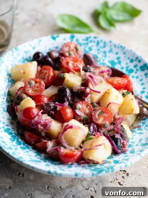 Italian Summer Vegetable Marinade Recipe for Fresh Antipasti 8 A Sicilian potato salad with olives, tomatoes and onions in a blue and white bowl.