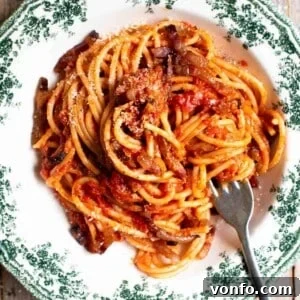 Spaghetti al Rancetto: Umbrian Tomato with Crispy Pancetta 9 A close up cropped image of past al rancetto with tomato, pancetta and onion.