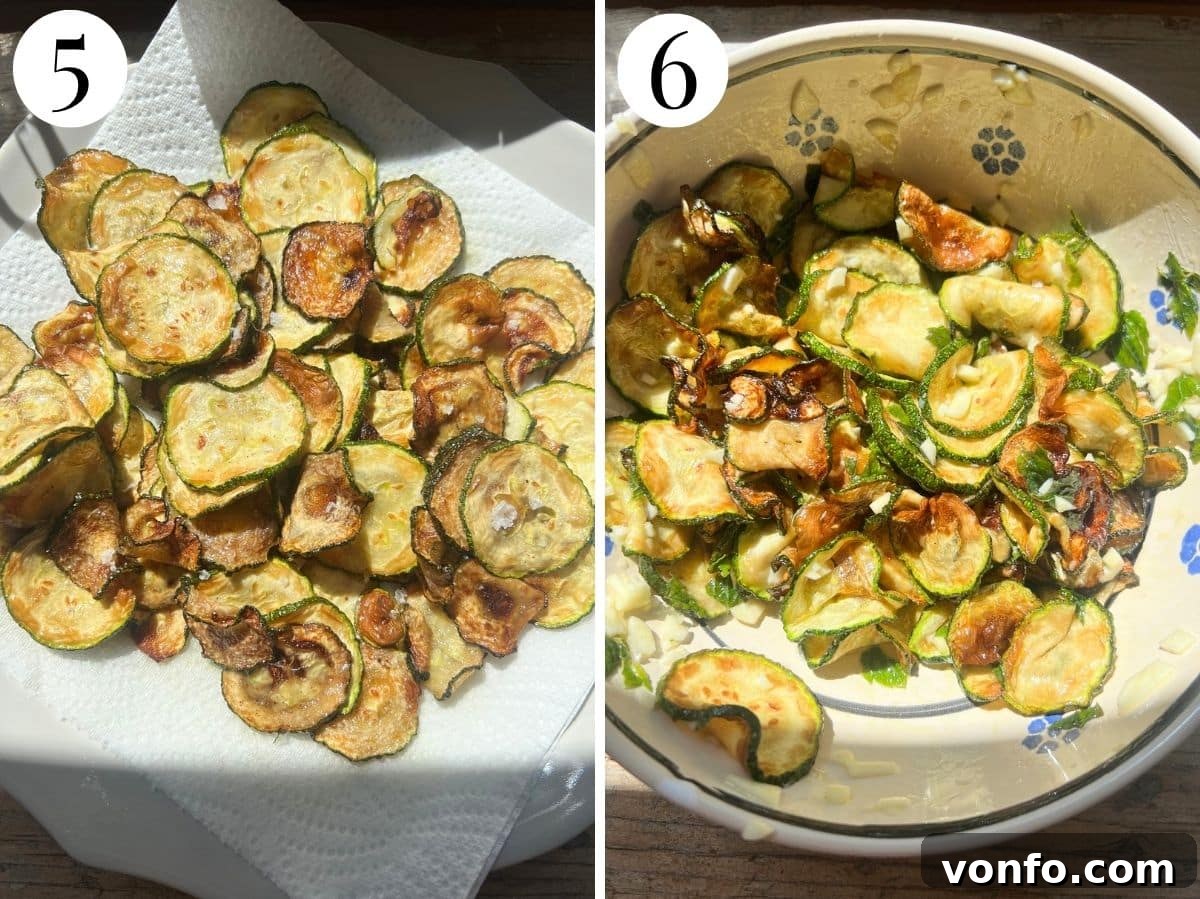Fried zucchini draining on a plate with kitchen paper and mixed with the vinegar, mint and garlic dressing.