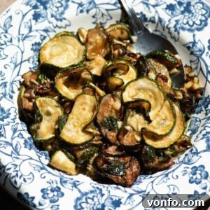 A cropped close up image of fried zucchini in a blue and white bowl.