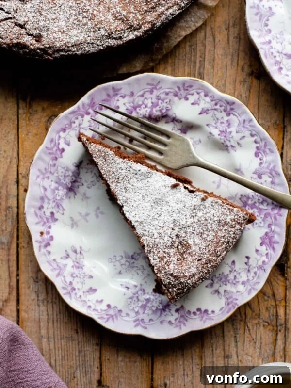 An overhead shot of a slice of chocolate torta caprese on a pink patterned plate