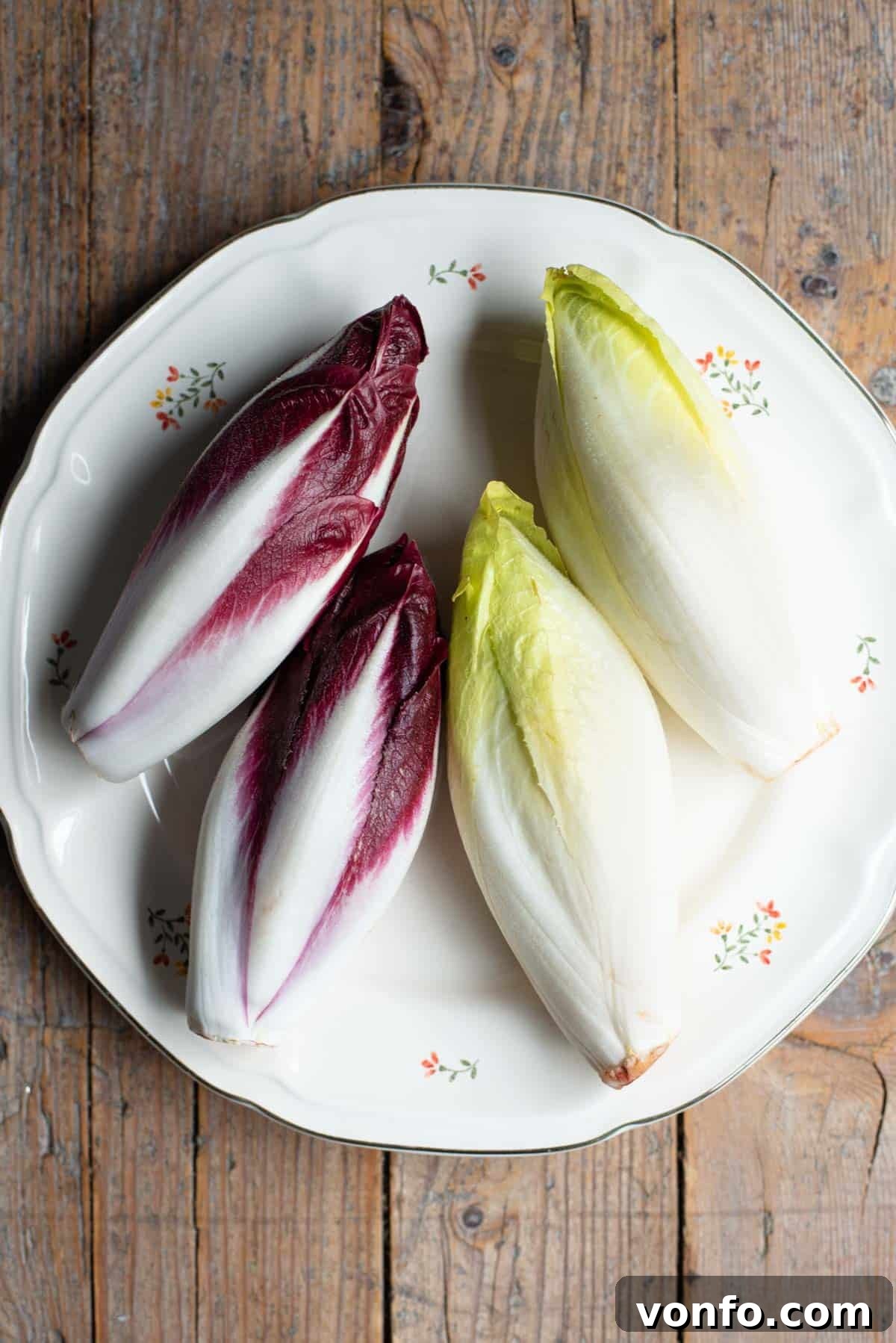 Italian Tramezzino: Beef with Radicchio, Cheese and Porchetta 4 An overhead shot of red and white chicory on a plate with a rustic wooden background.