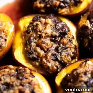 Piedmont-Style Baked Stuffed Peaches (Pesche Ripiene) 9 A close up of a baked peach stuffed with amaretti cookies and chocolate.