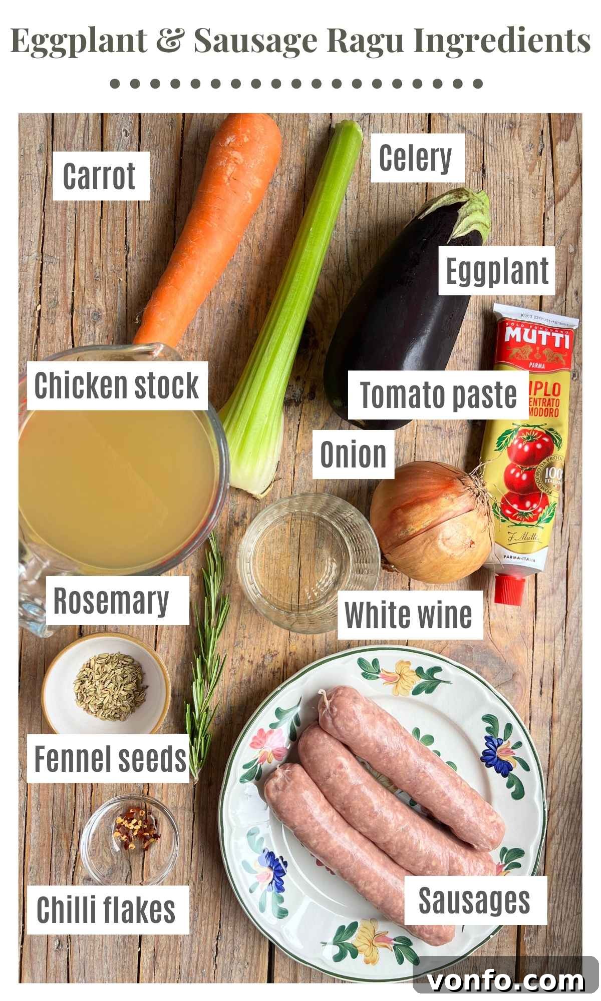 Slow-Braised Eggplant and Sausage Ragu 3 An overhead shot of all the ingredients needed to make a sausage and eggplant ragu laying on a wooden background.