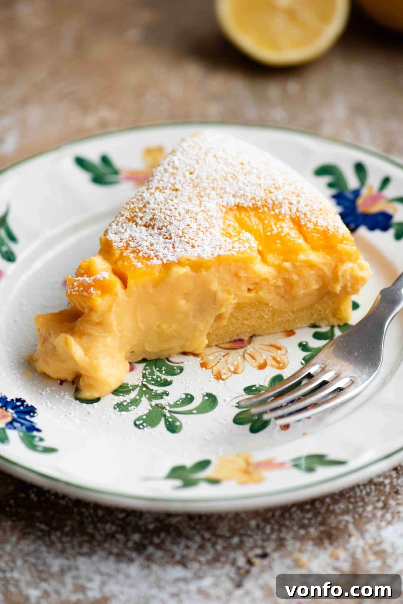 A close up of a slice of torta nua filled with pastry cream on a floral plate with a fork.